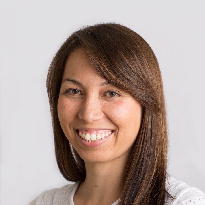 Corporate headshot of a smiling woman on a light background