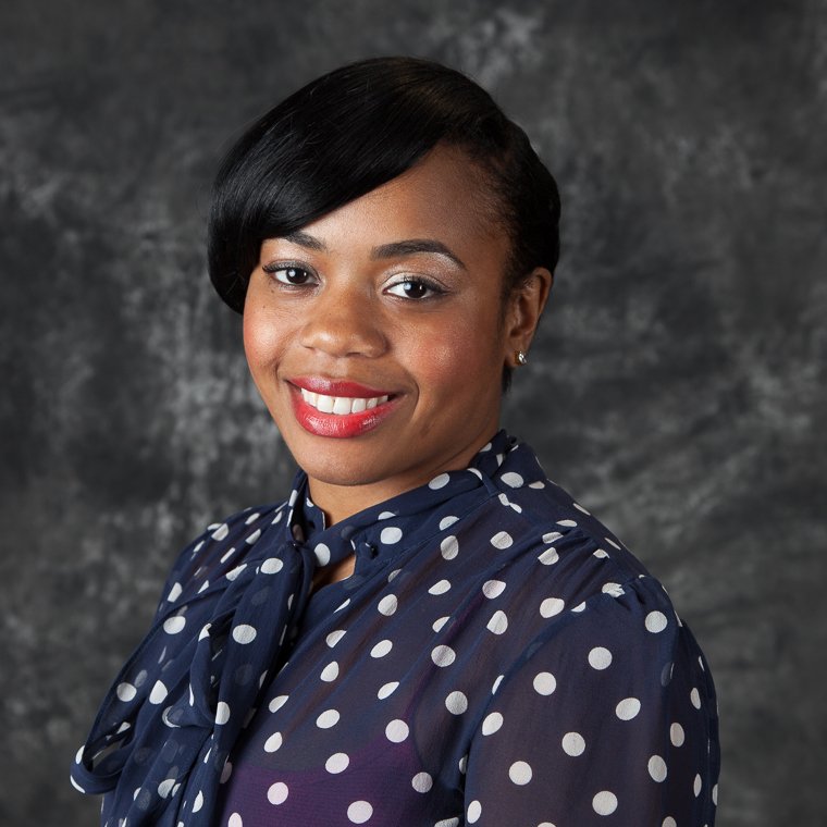 Professional headshot of a smiling woman in a polka-dot blouse